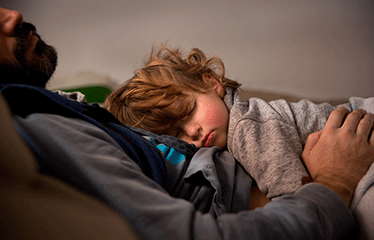 Child asleep on a mans chest 